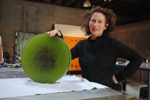 Mayme Kratz in her studio holding a small resin piece in its final stages.