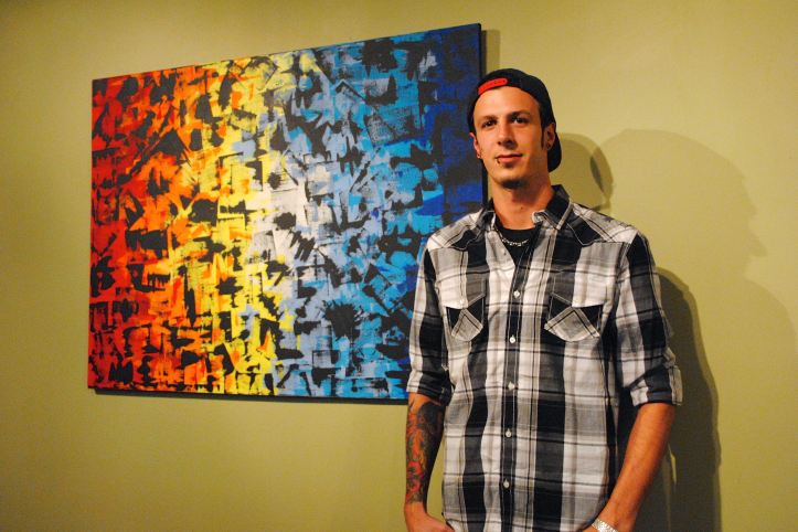Luke Kaminski forgoes the paintbrush to use a credit card dipped in paint to create his abstract works. His paintings are up at the new Skyline Lofts Art Gallery.